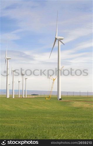 Solar powered wind turbines and crane in remote field