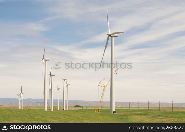 Solar powered wind turbines and crane in remote field