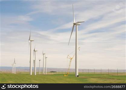 Solar powered wind turbines and crane in remote field