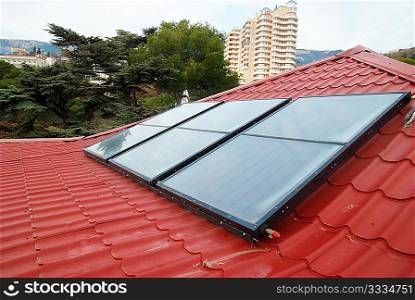 Solar water heating system (geliosystem) on the red house roof.