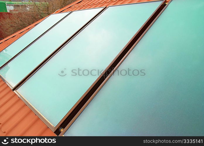 Solar water heating system (geliosystem) on the red house roof.