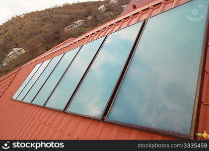 Solar water heating system (geliosystem) on the red house roof.