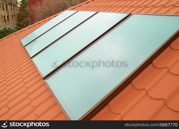 Solar water heating system (geliosystem) on the red house roof.