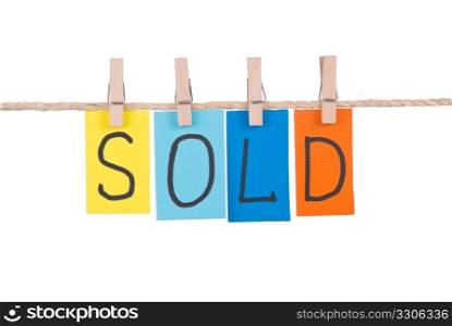 Sold, Colorful words hang on rope by wooden peg