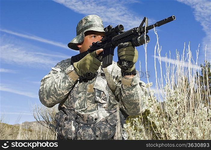 Soldier aiming machine gun