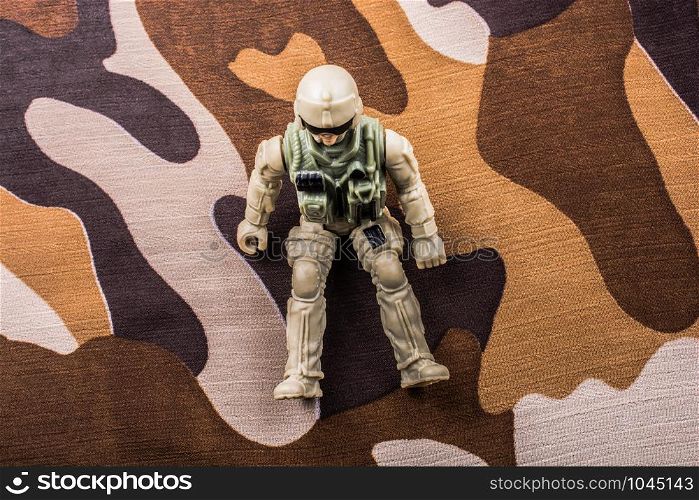 Soldier figurine on a camo background in the view