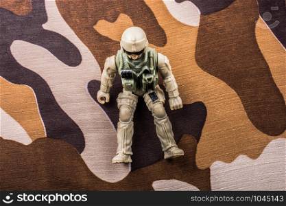 Soldier figurine on a camo background in the view