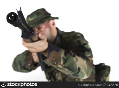 Soldier is aiming. The focus is placed to the muzzle while the man himself is out of focus in anonimity.