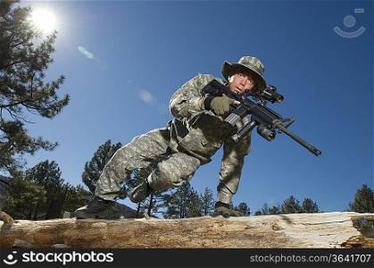 Soldier jumping over log
