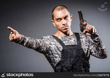 Soldier with guns against dark background