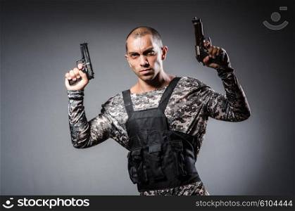 Soldier with guns against dark background