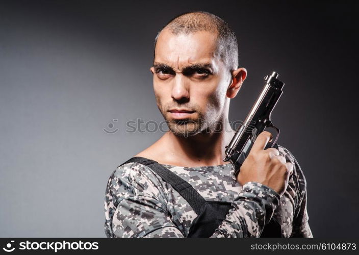 Soldier with guns against dark background