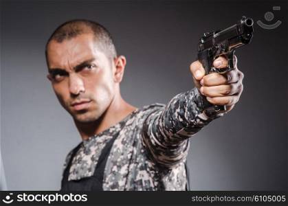 Soldier with guns against dark background