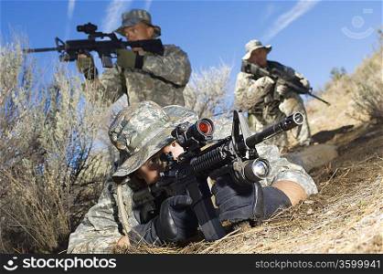Soldiers aiming machine guns