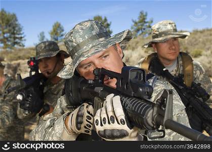 Soldiers aiming machine guns