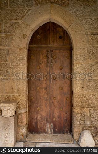 Solid wood and reinforced arched door inside historic monastery in Guimaraes. Arched door inside historic monastery in Guimaraes