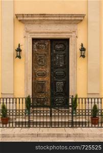 Solid wooden entrance doors to Kyra-Panagia Faneromeni or Virgin of Strangers church. Kyra Panagia Faneromeni church in Old Town Corfu