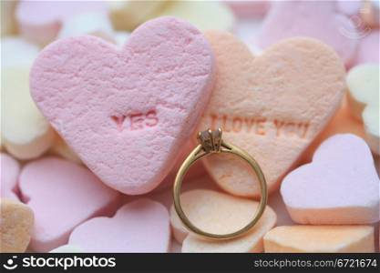 Solitaire diamond engagement ring on valentine candy heart with yes I love you text
