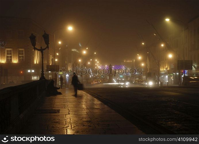 Solitary figure on bridge in Cork by night, Ireland