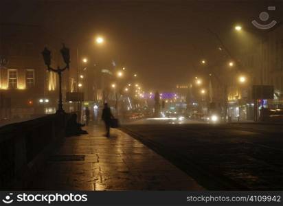 Solitary figure on bridge in Cork by night, Ireland