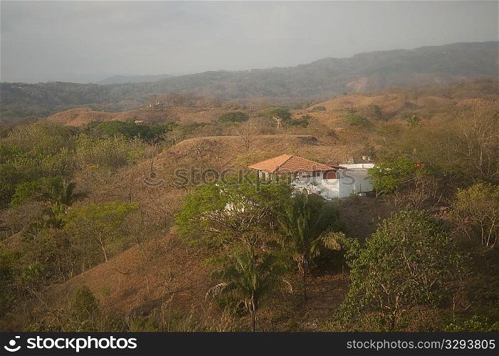 Solitary white house with an orange roof in the hilltops of Costa Rica