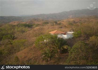 Solitary white house with an orange roof in the hilltops of Costa Rica