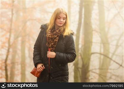 Solitude concept. Sad lonely woman walking relaxing in foggy day in romantic autumn forest park outdoor