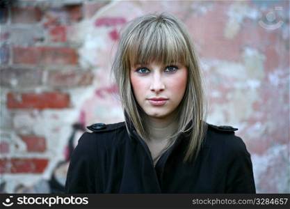 solitude - cute blonde girl against obsolete brick wall background