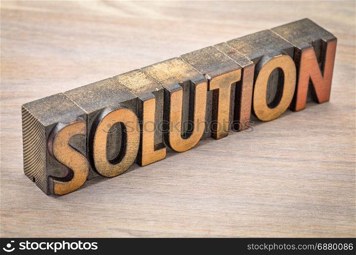 solution word abstract in vintage letterpress wood type against grained wood