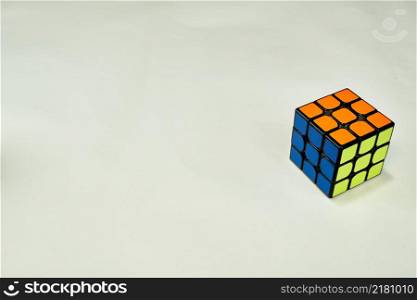 solved rubik&rsquo;s cube in blue, yellow and orange on white background with copy space.. solved rubik&rsquo;s cube in blue yellow and orange on white background with copy space