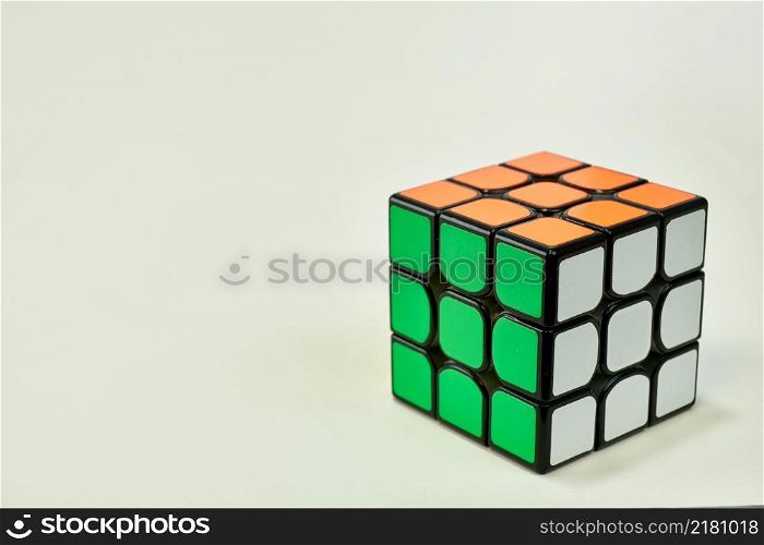 solved rubik&rsquo;s cube in white, green and orange on white background.. solved rubik&rsquo;s cube in white, green and orange on white background