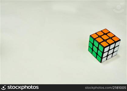 solved rubik&rsquo;s cube in white, green and orange on white background with copy space.. solved rubik&rsquo;s cube in white green and orange on white background with copy space