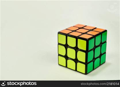 solved rubik&rsquo;s cube in yellow, green and orange on white background.. solved rubik&rsquo;s cube in yellow, green and orange on white background