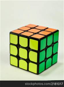 solved rubik&rsquo;s cube in yellow, green and orange on white background vertical.. solved rubik&rsquo;s cube in yellow, green and orange on white background vertical