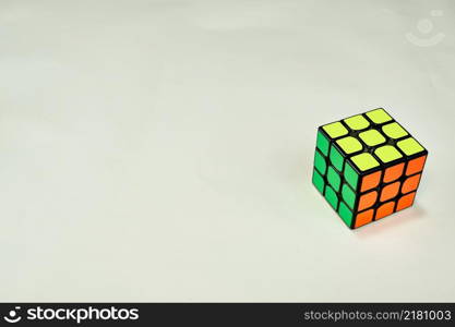 solved rubik&rsquo;s cube in yellow, green and orange on white background with copy space .. solved rubik&rsquo;s cube in yellow, green and orange on white background with copy space