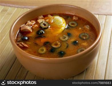 Solyanka on the plate.Solyanka, Russian soup with beef,sausage,chicken and lemon, olives