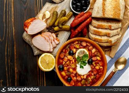 Solyanka - Russian traditional meat soup on wooden background. Solyanka - Russian traditional meat soup