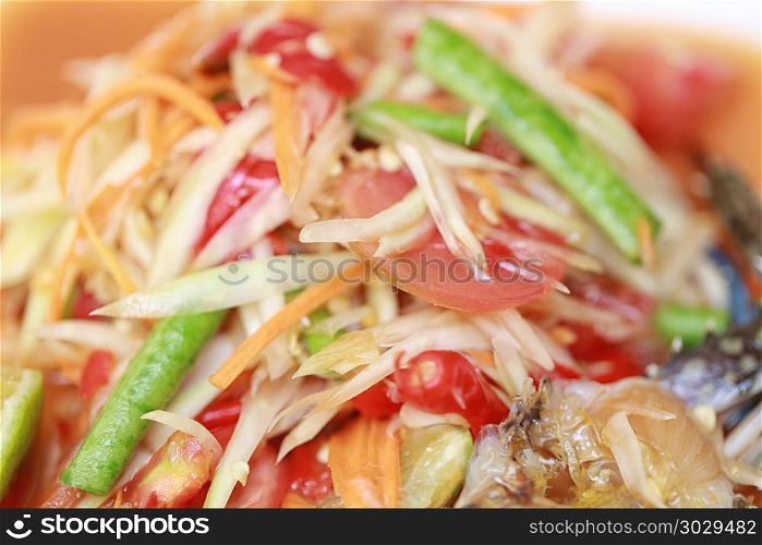 SOM TUM,Thai foods or papaya salad in spicy taste and is popular. SOM TUM,Thai foods or papaya salad in spicy taste and is popular in Thailand on wooden table background.