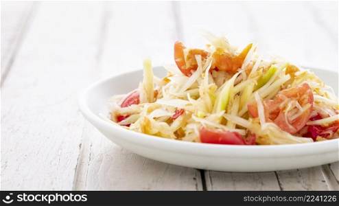 Som Tum Thai, Som Tam Thai, Thai food, spicy papaya salad with, tomato, lime and chilli topping with dried shrimp on white old wood texture background, light and airy food photography