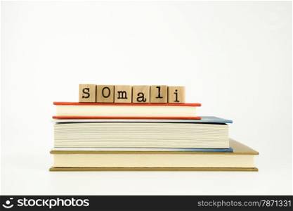 somali word on wood stamps stack on books, conversation and translation concept