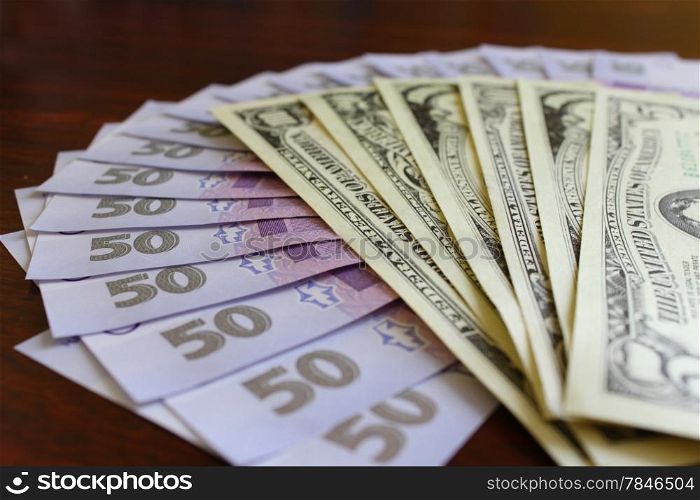 Some dollar and grivnas banknotes isolated on dark background