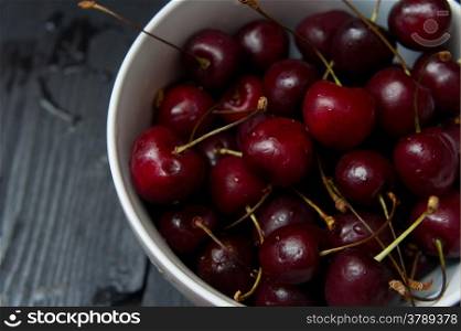 some fresh ripe red cherries on black table