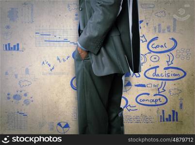 Some ideas for success. Bottom view of businessman and sketches of ideas on wall