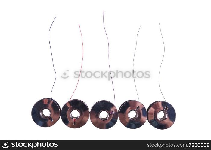 Some metal spools with multicoloured threads isolated on white