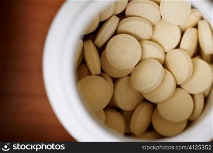 some pills in white container, selective focus on nearest, see other health related images in my portfolio