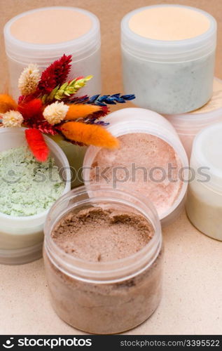 some plastic jars with coloured saline body scrub
