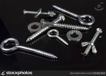 some screws, nuts and hardware store on a black background