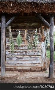 Some species of herbs are withering, hanging on a linen string outdoors at front of old cottage. Healing by the natural, organic treatment