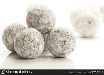 some sugar powder covered truffle pralines. some sugar powder covered truffle pralines on white background