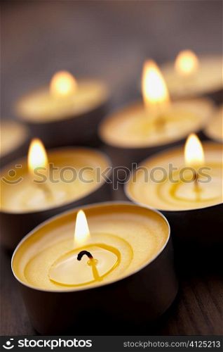 some tealight on wooden table, selective focus on nearest
